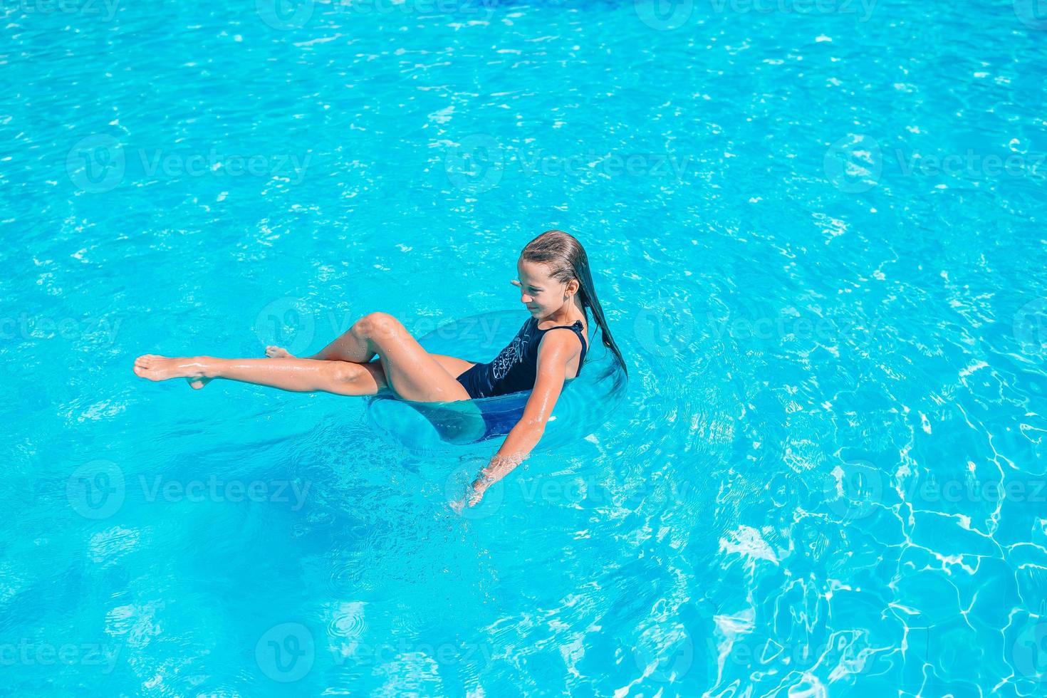 Little adorable girl in outdoor swimming pool photo