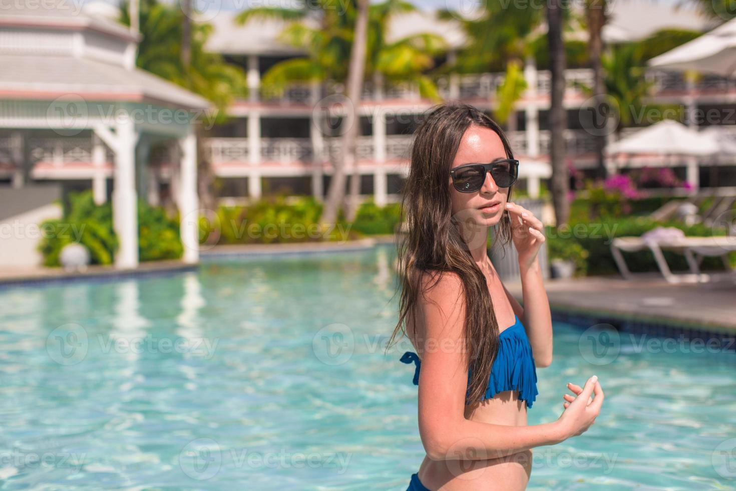 Young beautiful woman relaxing in swimming pool photo