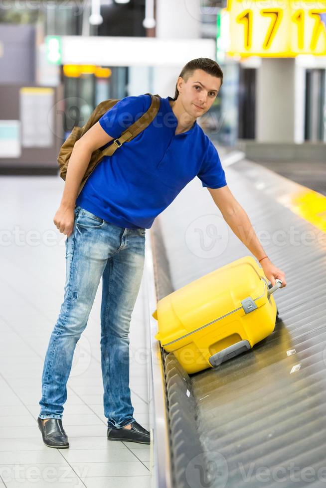 Beautiful man with passports and boarding passes at the front desk at airport photo