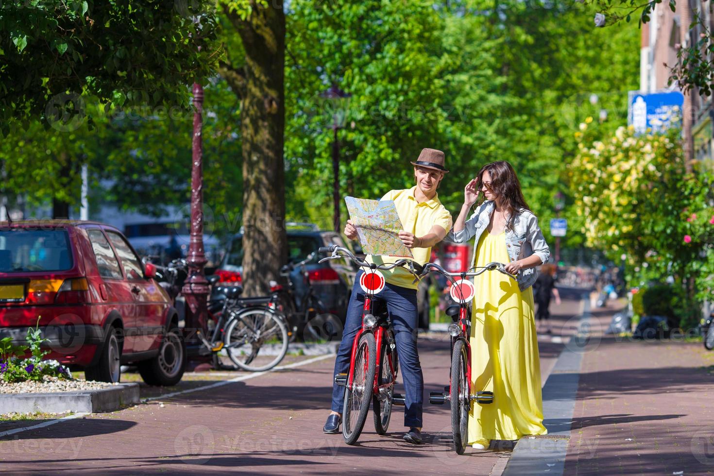 Young happy couple with city map on bikes in Amsterdam photo