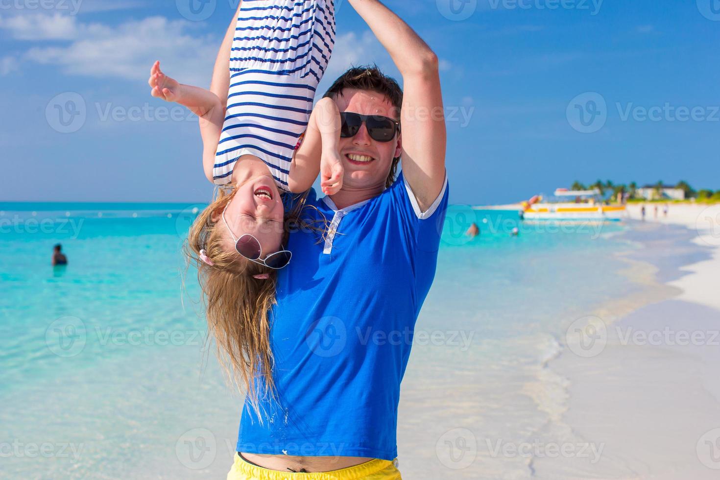 Happy dad have fun with his little cute girl at perfect beach photo