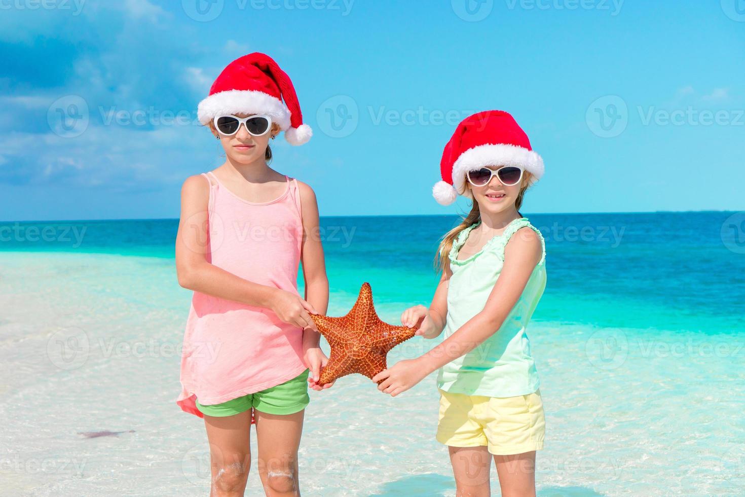 Adorable little girls on Christmas beach vacation. photo