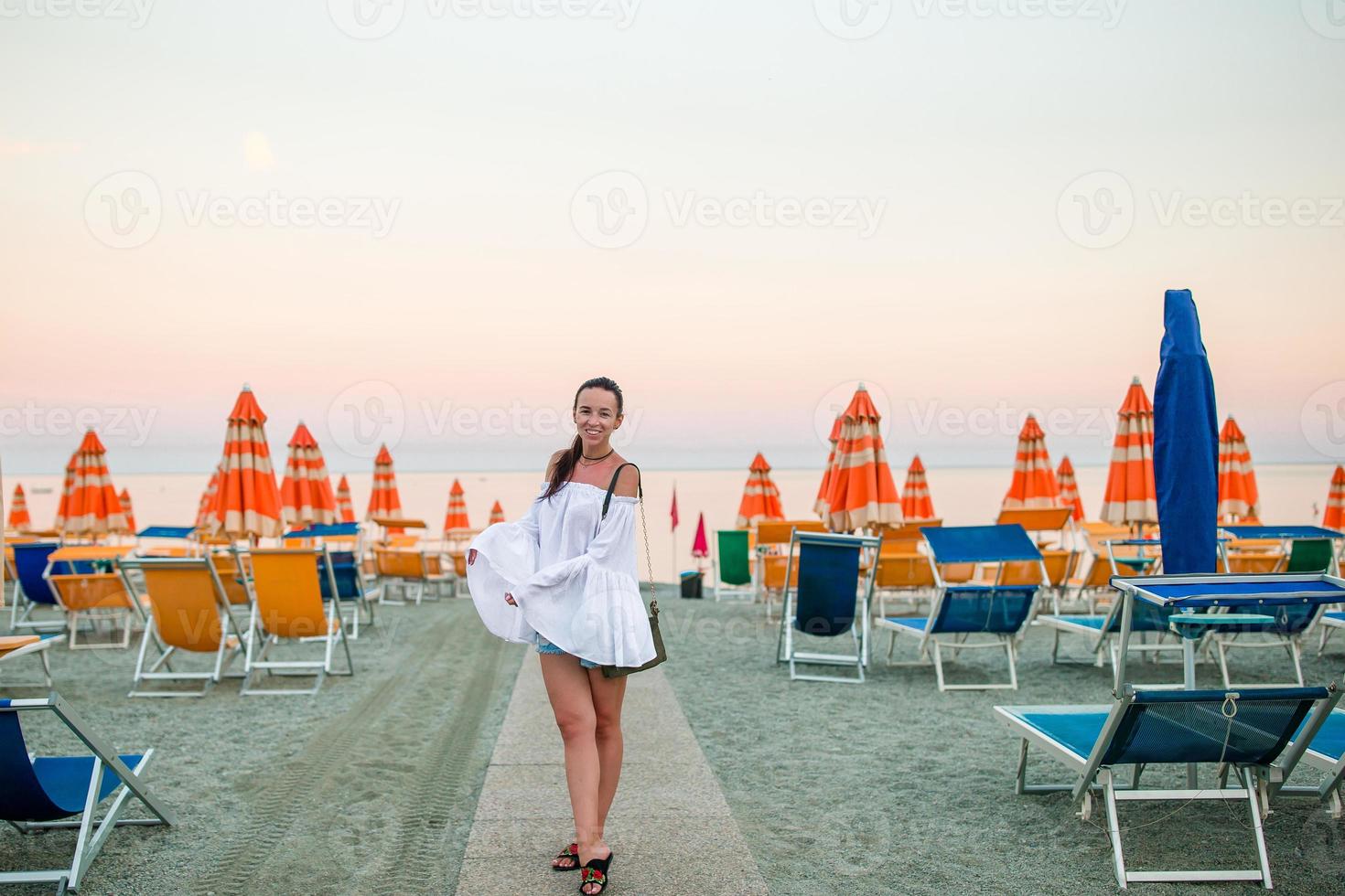 Young woman on the empty beach at sunset photo