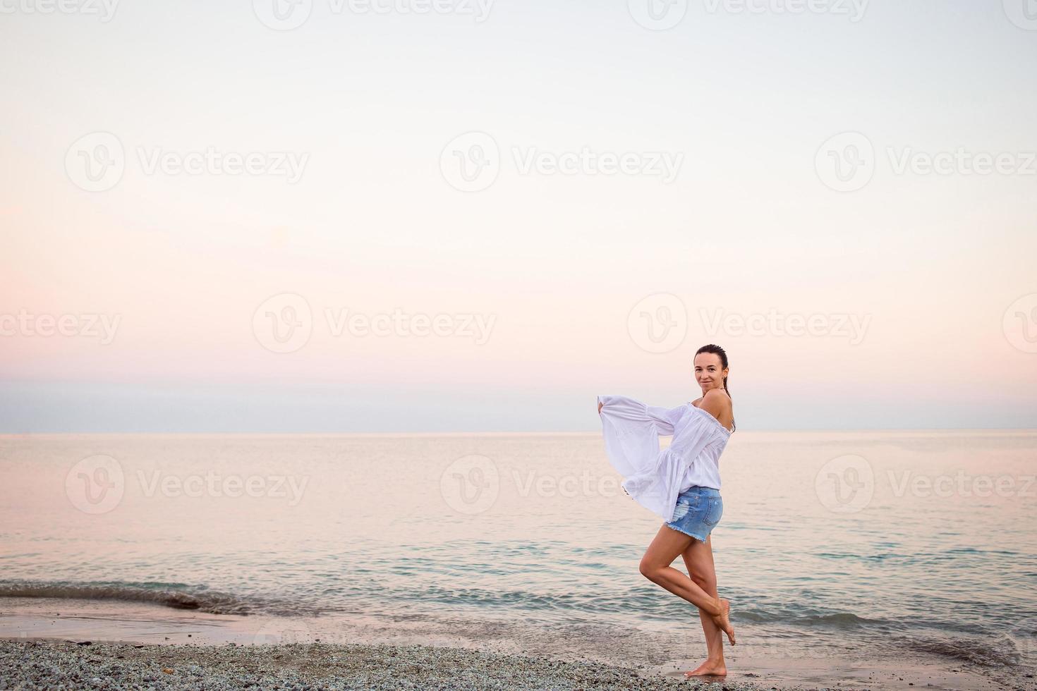Young woman on the beach in european vacation on the Ligurian coast in sunset photo