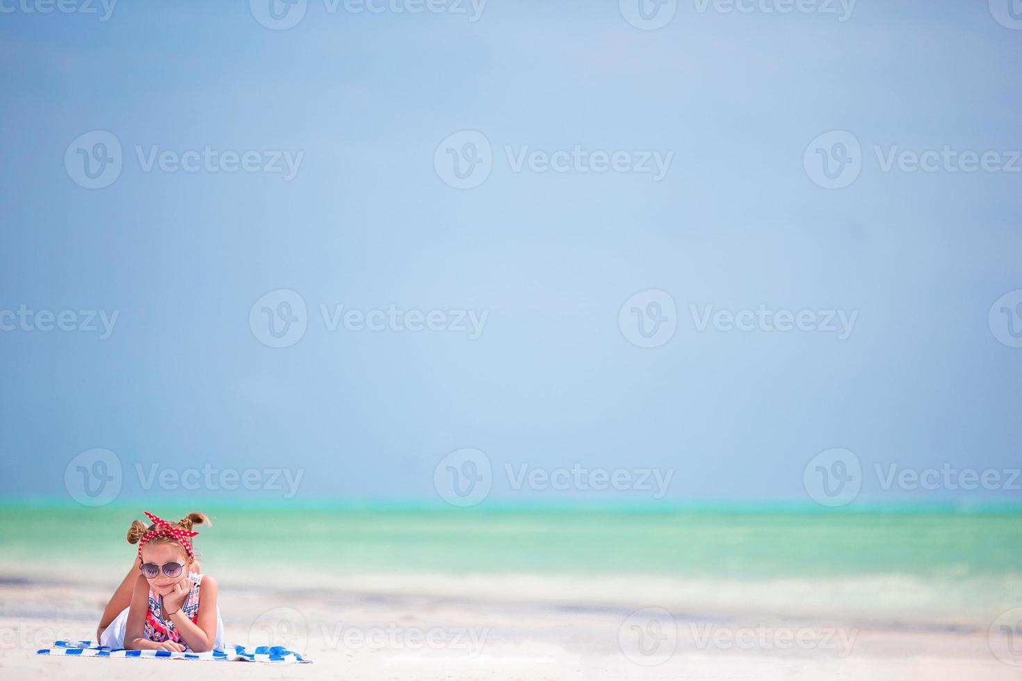 Beautiful little girl in dress at the beach. Funny girl enjoy summer vacation. photo