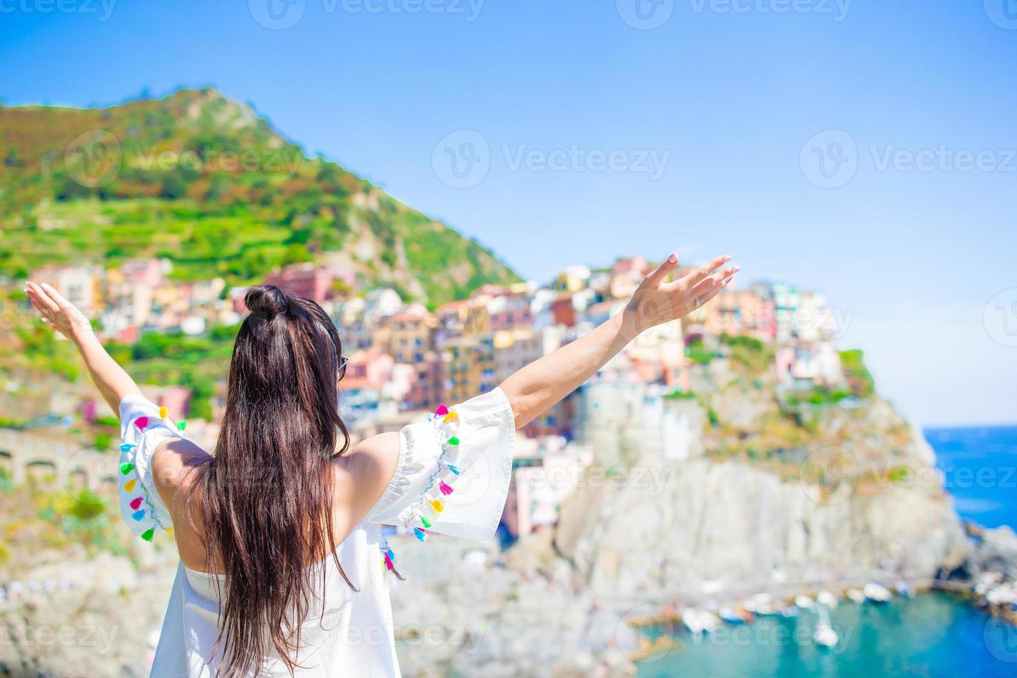 Back view of happy girl background beautiful view of Manarola, Cinque Terre, Liguria, Italy photo