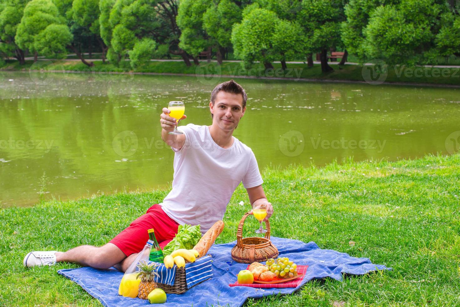 joven feliz haciendo un picnic y relajándose al aire libre foto