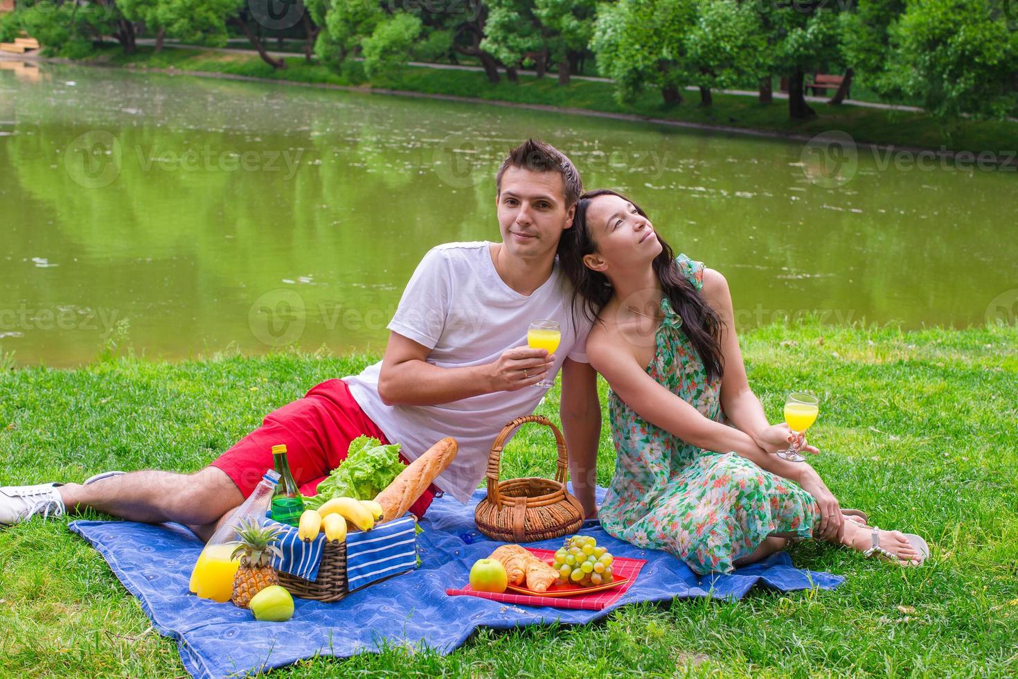 Young happy couple picnicking and relaxing outdoors photo