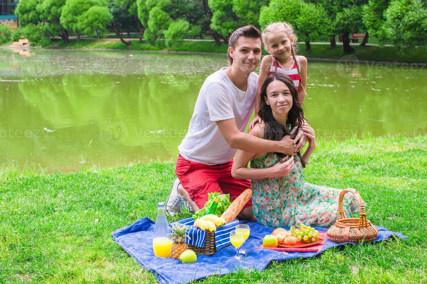 Happy cute family of three picnicking outdoor photo