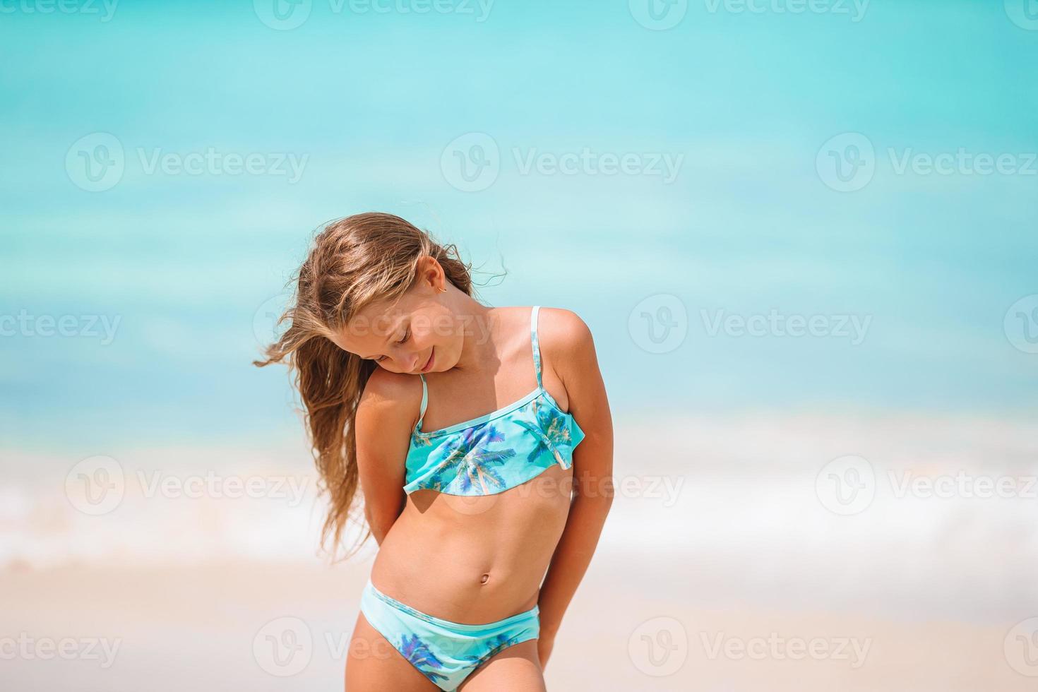 Cute little girl at beach during summer vacation photo