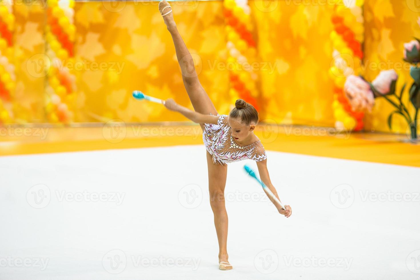 hermosa niña gimnasta activa con su actuación en la alfombra foto