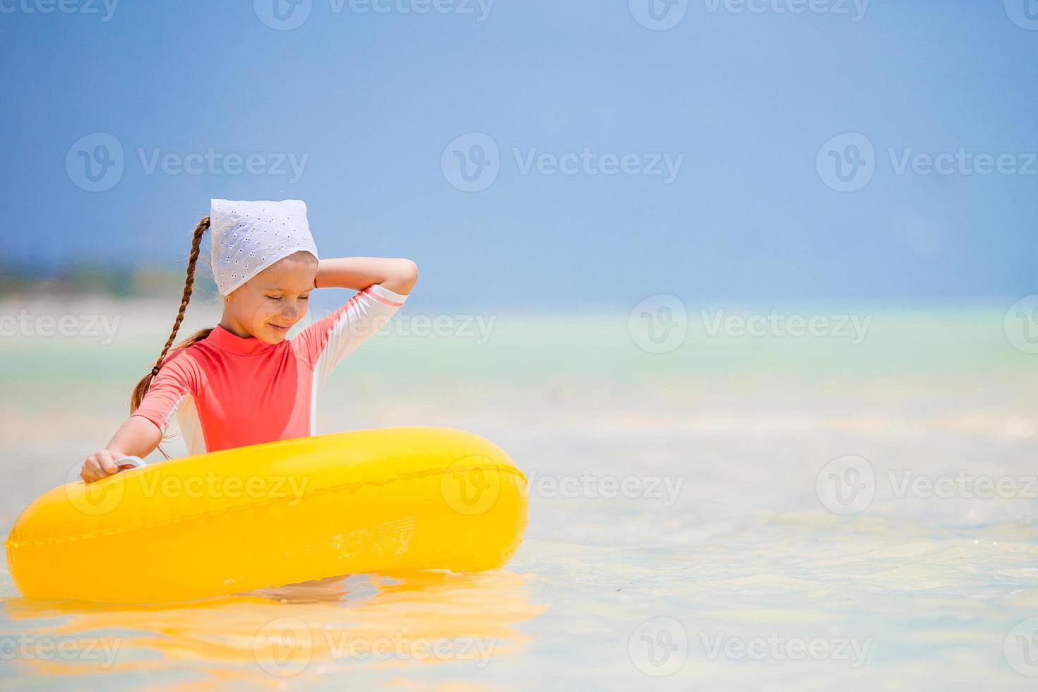 Happy kid with inflatable rubber circle having fun on the beach photo