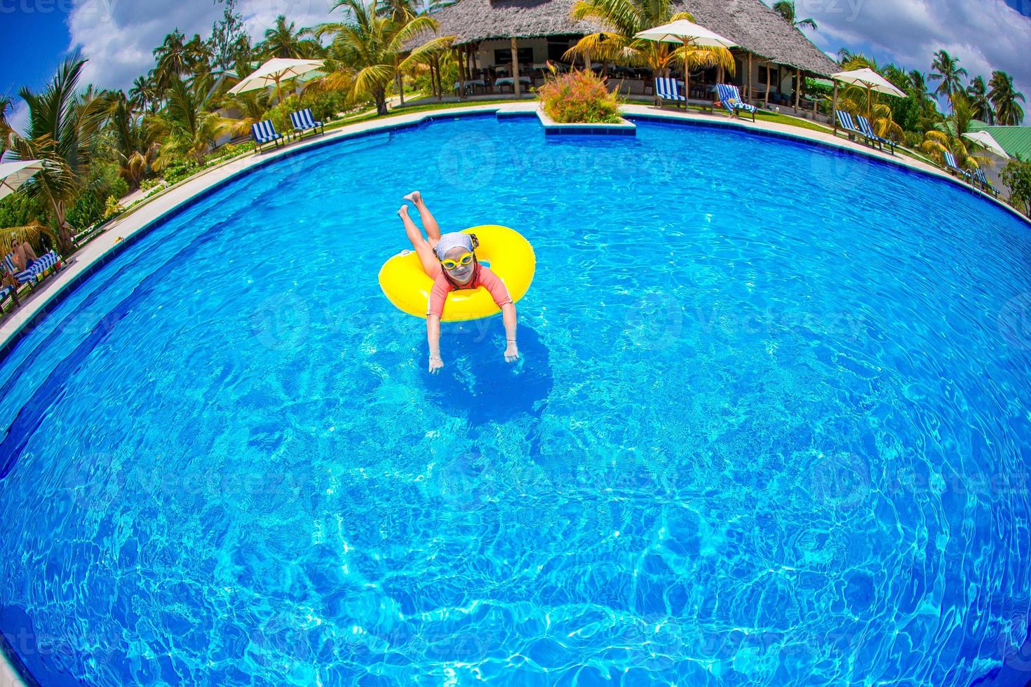 Happy kid with inflatable rubber circle having fun on the beach photo