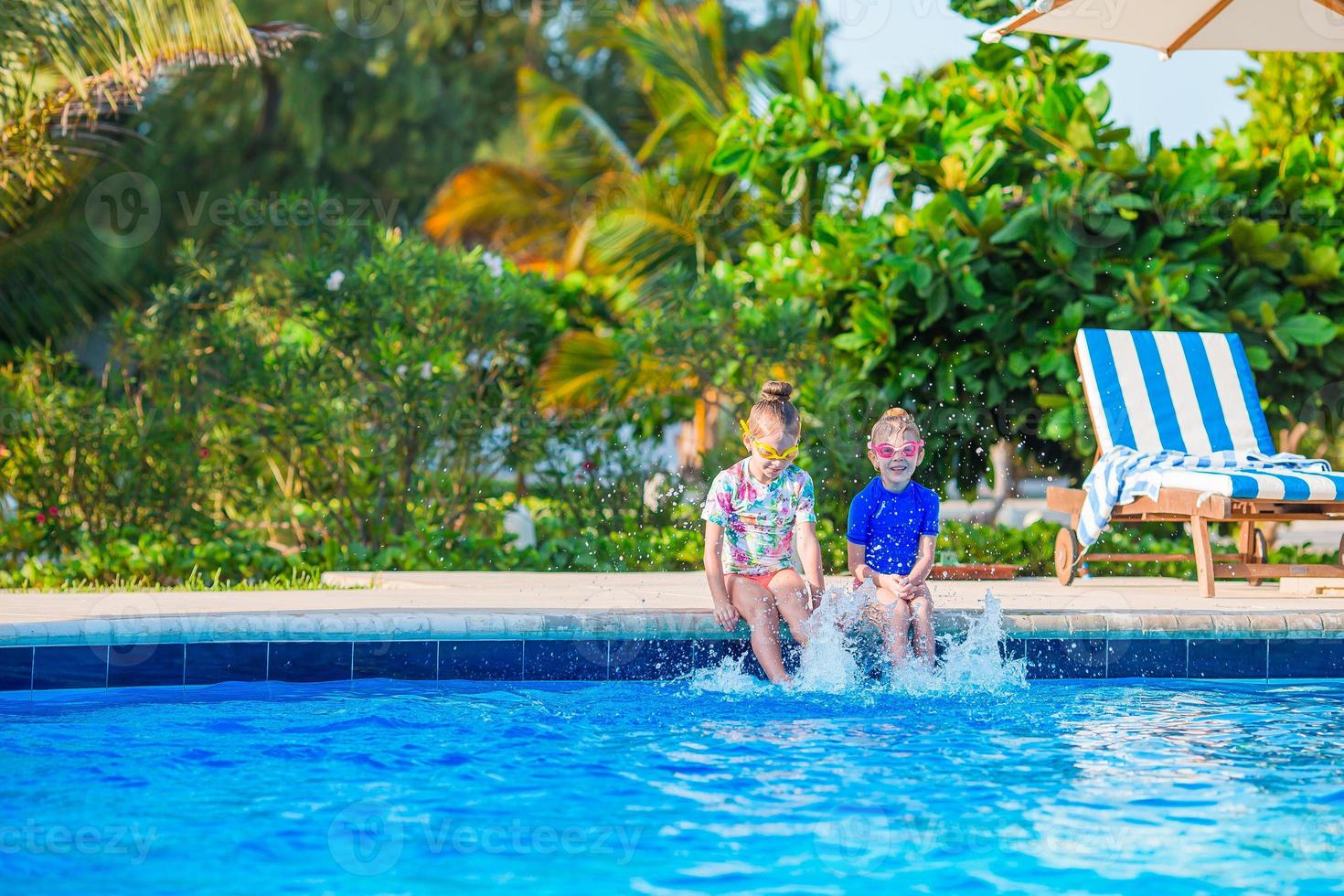 Family of mom and little daughter enjoying summer vacation in luxury swimming pool photo