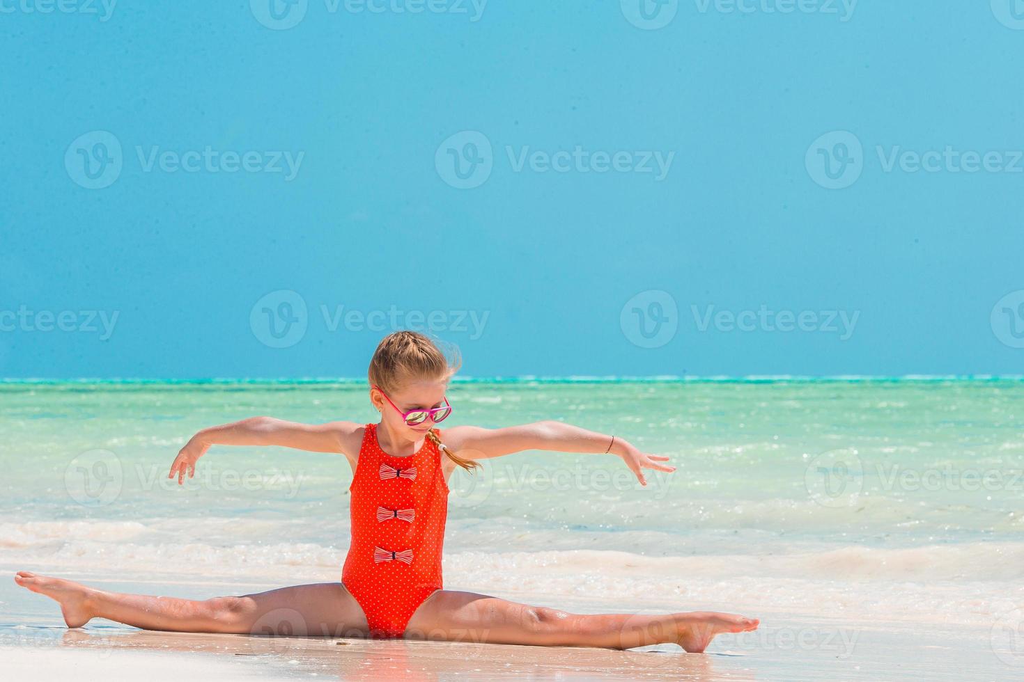 niña activa en la playa blanca divirtiéndose foto