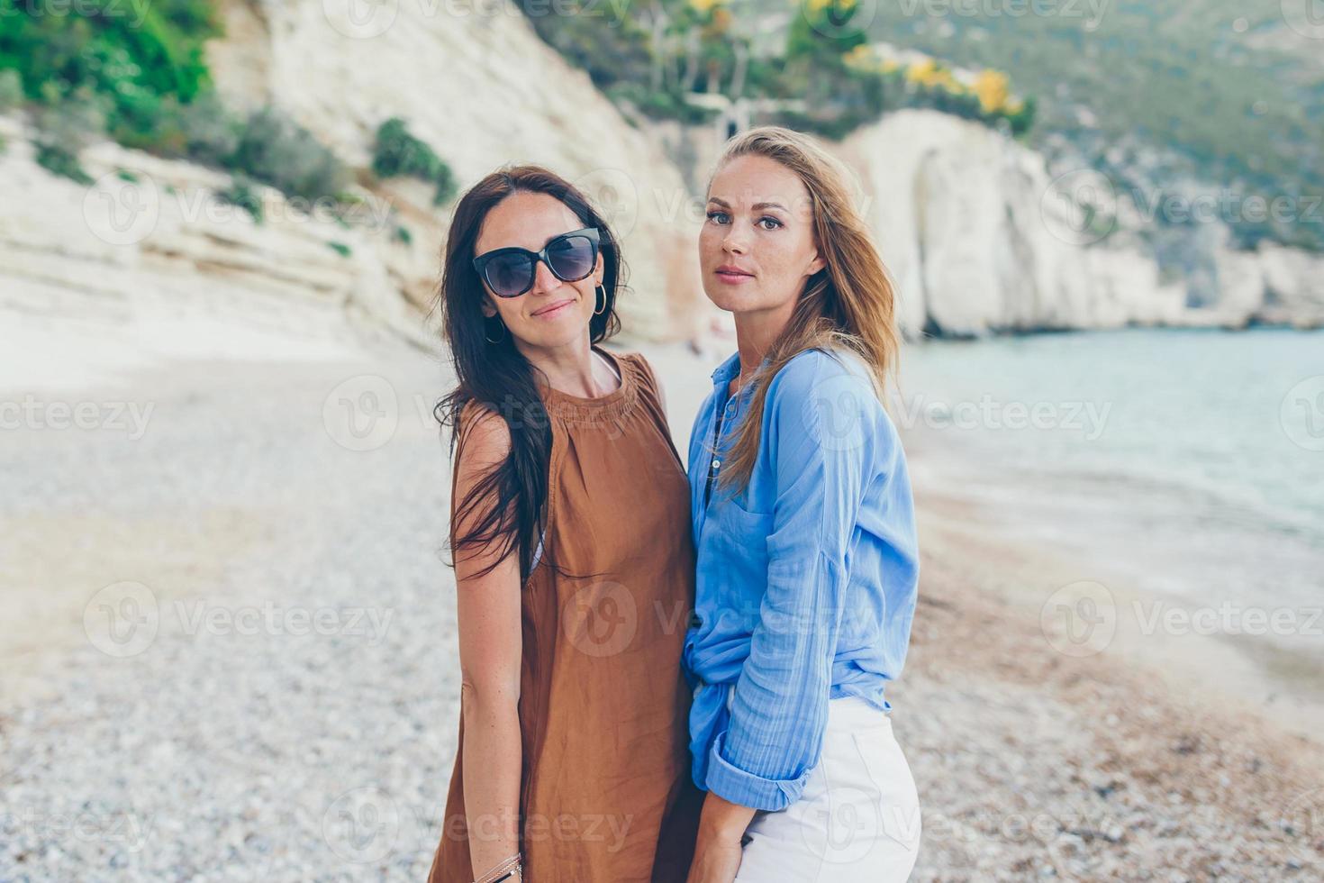 Women on the beach enjoying summer holidays looking at the sea photo