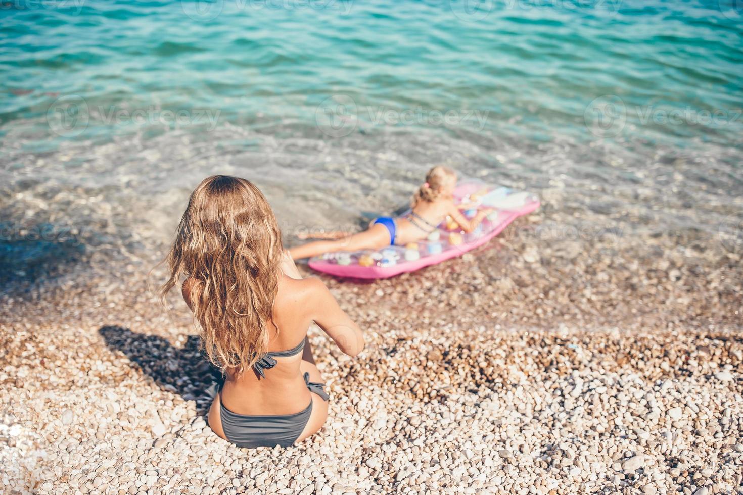 mujer joven disfrutando del sol tomando el sol junto al océano turquesa perfecto foto