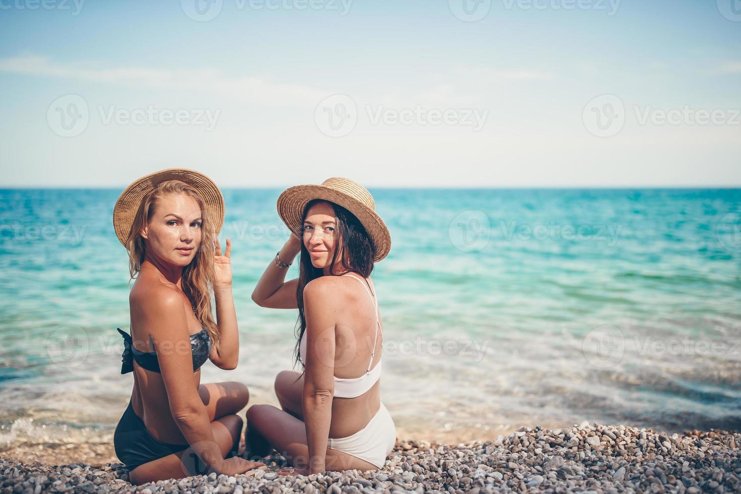 Women laying on the beach enjoying summer holidays looking at the sea photo