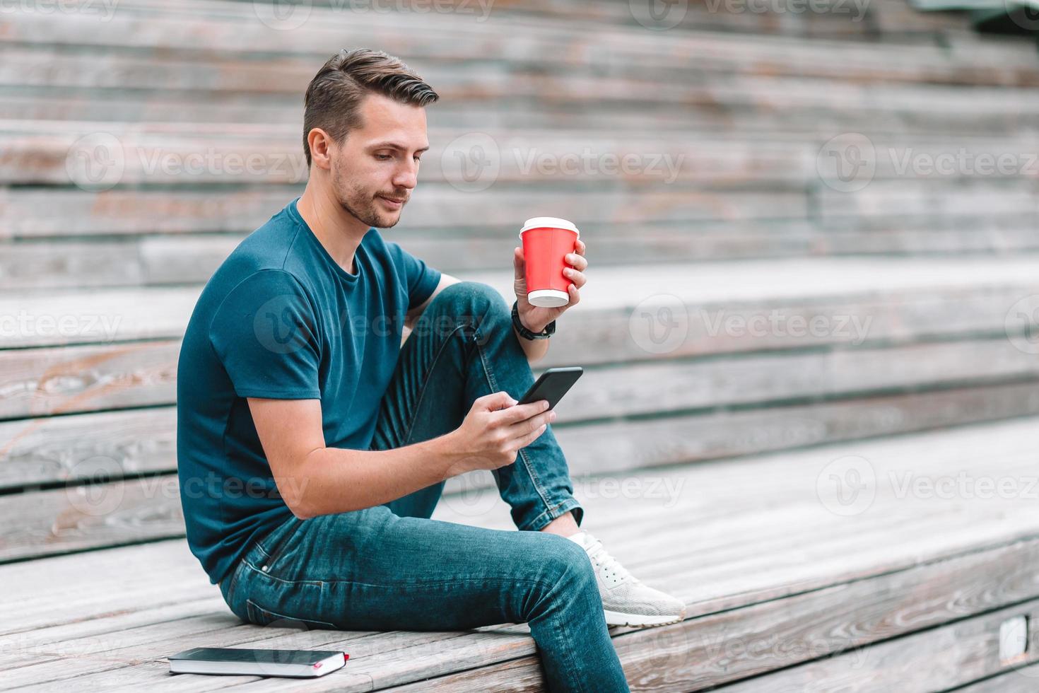 el hombre está leyendo un mensaje de texto en el teléfono móvil mientras camina en el parque foto