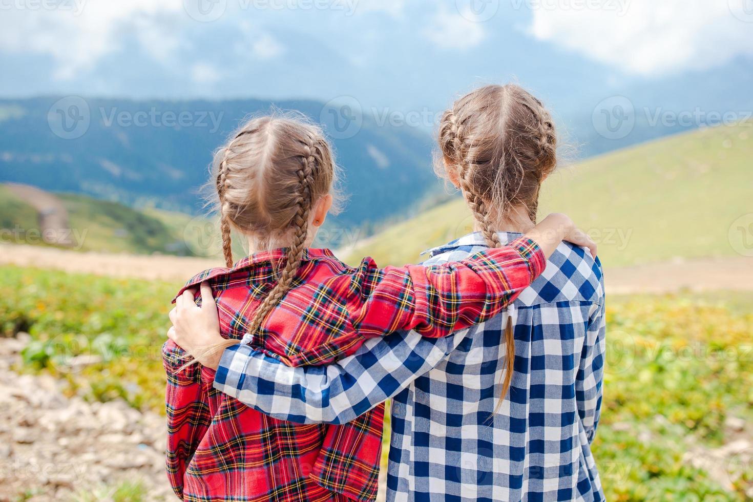 Beautiful happy little girls in mountains in the background of fog photo