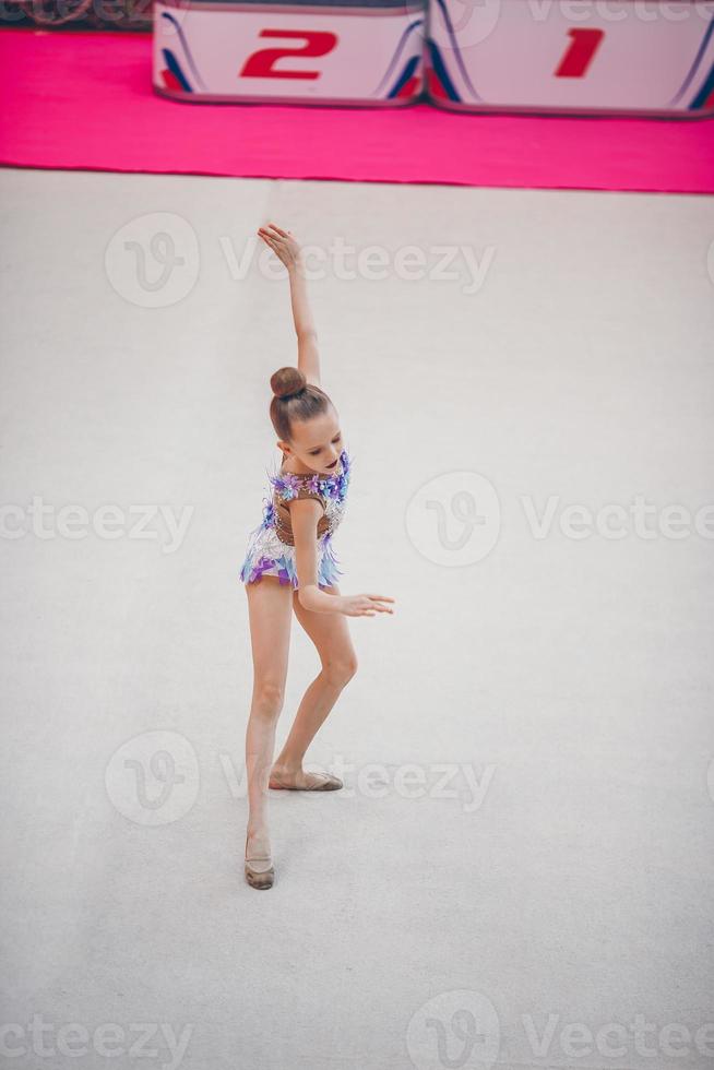 hermosa niña gimnasta activa con su actuación en la alfombra foto