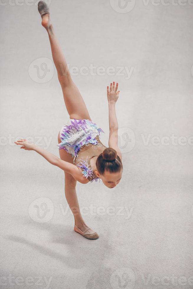 hermosa niña gimnasta activa con su actuación en la alfombra foto