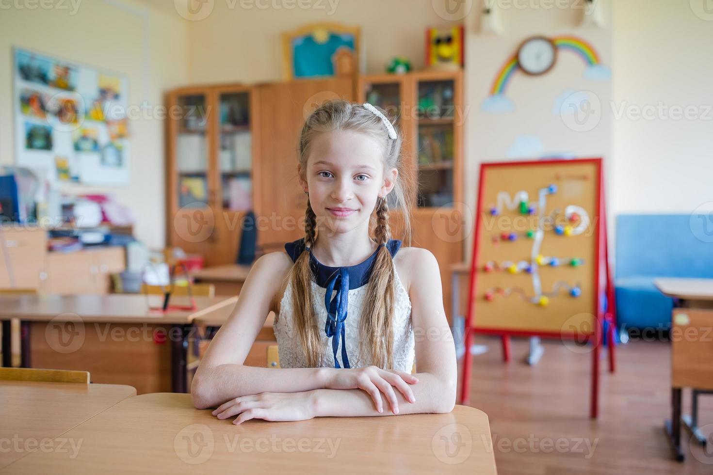 Adorable little school girl with notes and pencils outdoor. photo