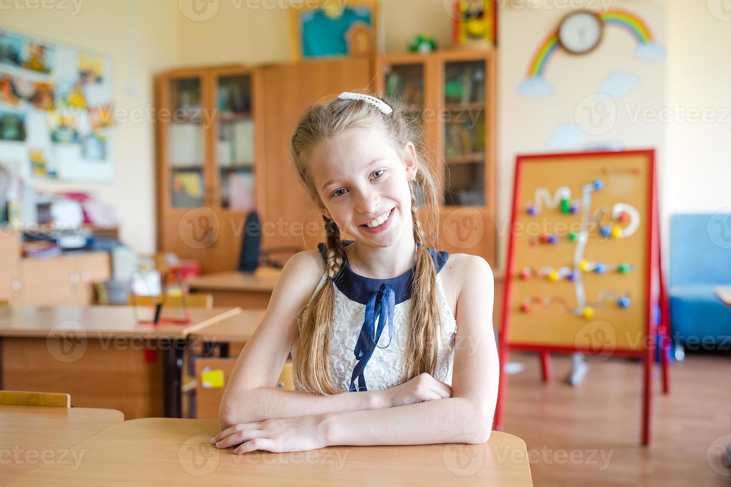 Adorable little school girl with notes and pencils outdoor. photo