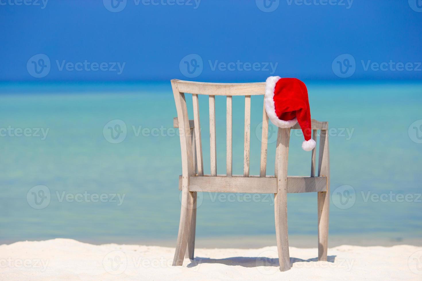 Red santa hat on beach chair at tropical vacation photo