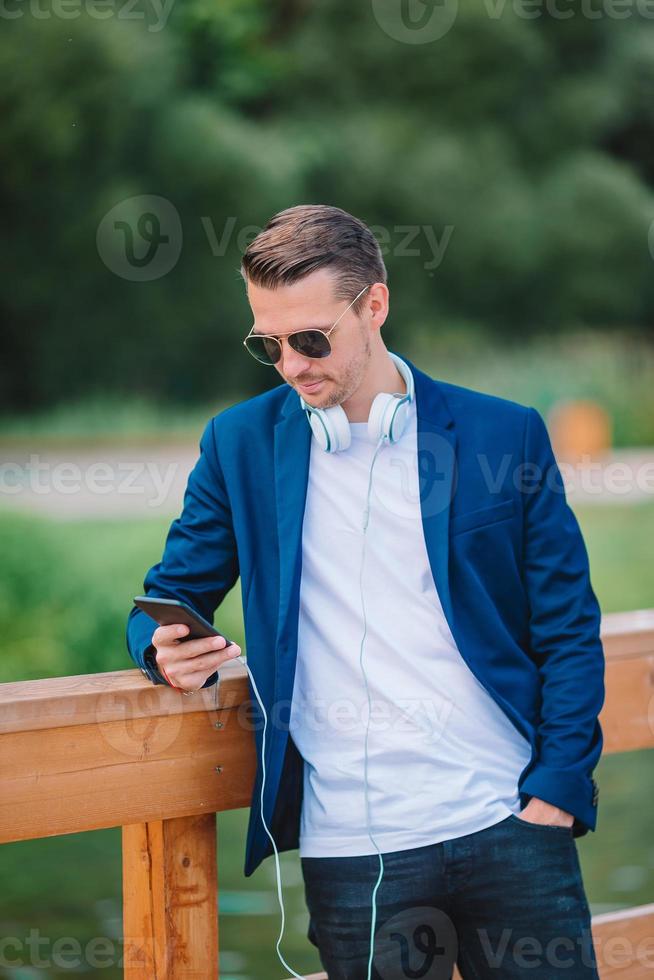 Happy young urban man working and drinking coffee in european city outdoors photo