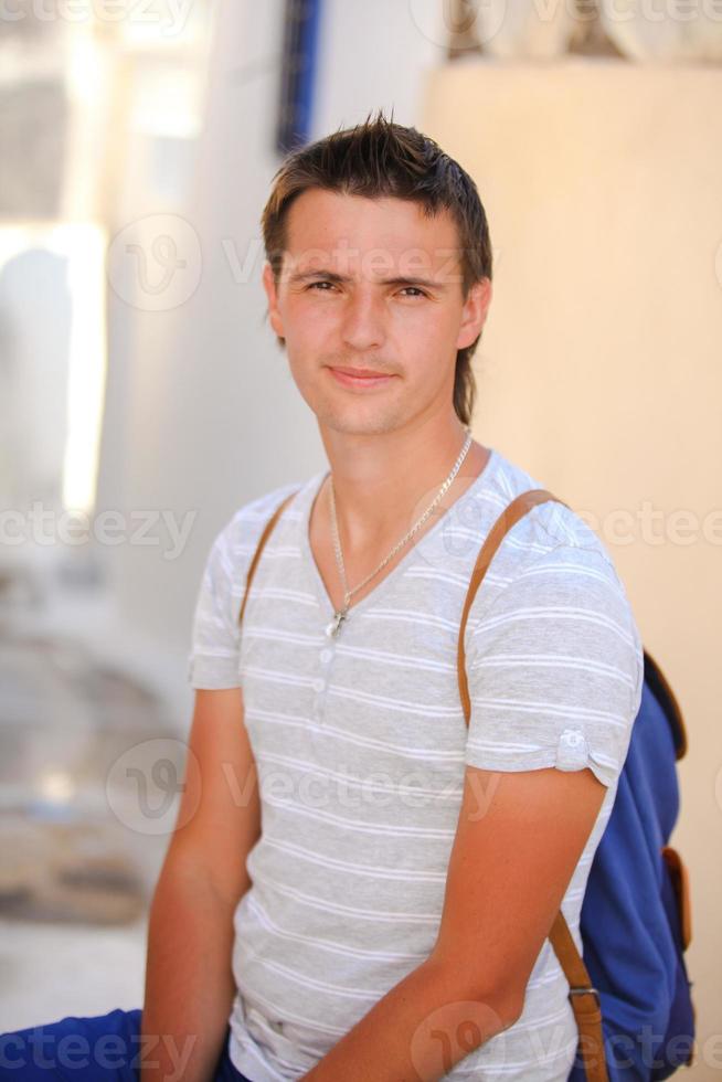 Portrait of young man sitting at street in Greek village, Emporio, Santorini photo