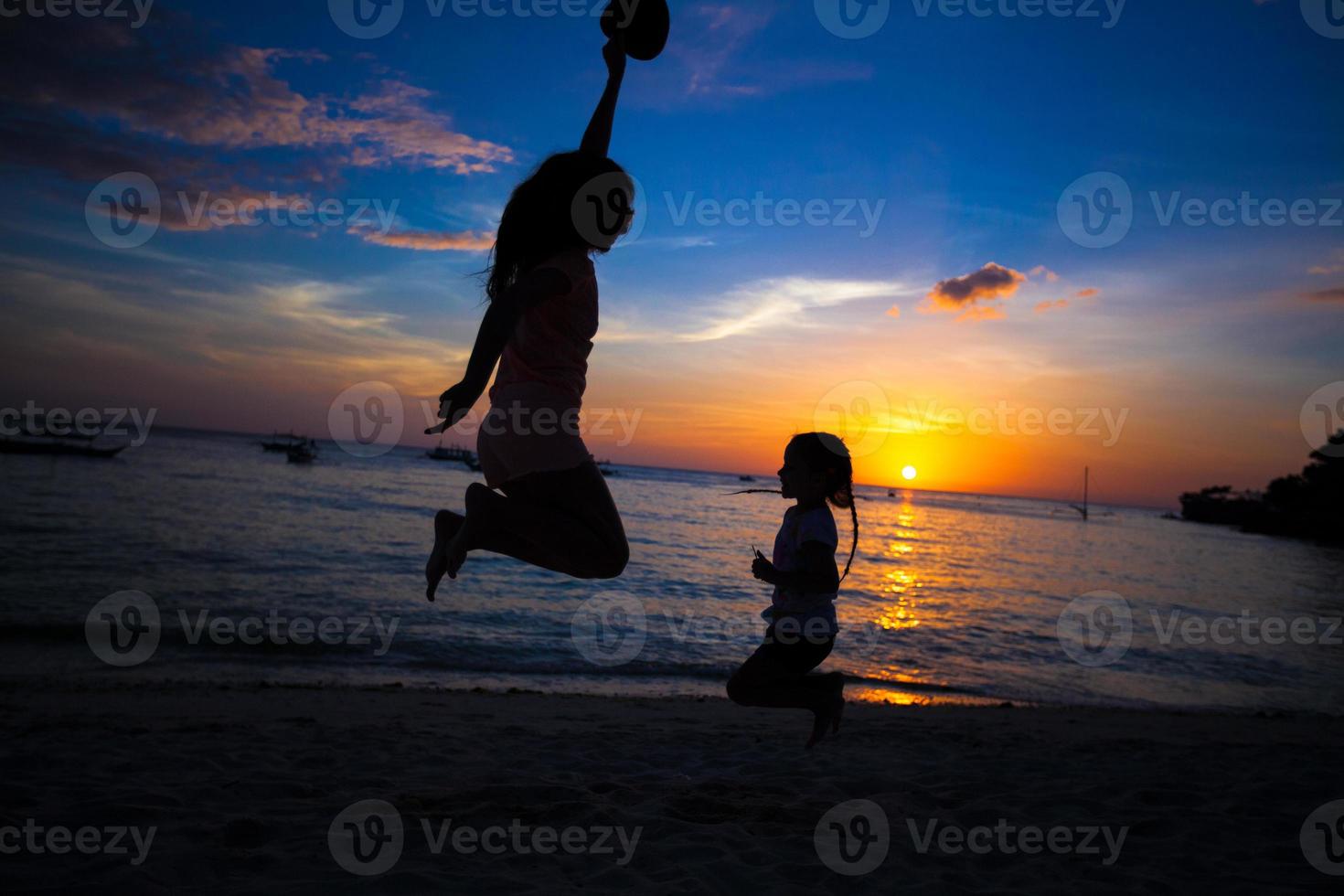 Silhouette of mother and little daughter playing on the beach in Boracay, Philippines photo