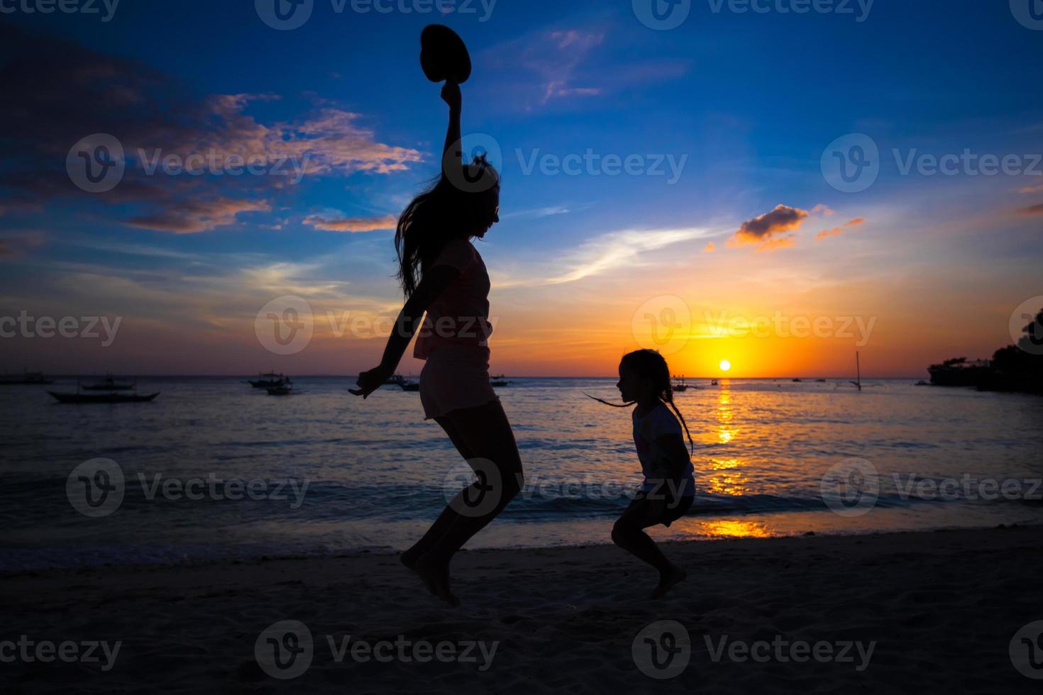 Silhouette of mother and little daughter playing on the Boracay beach, Philippines photo