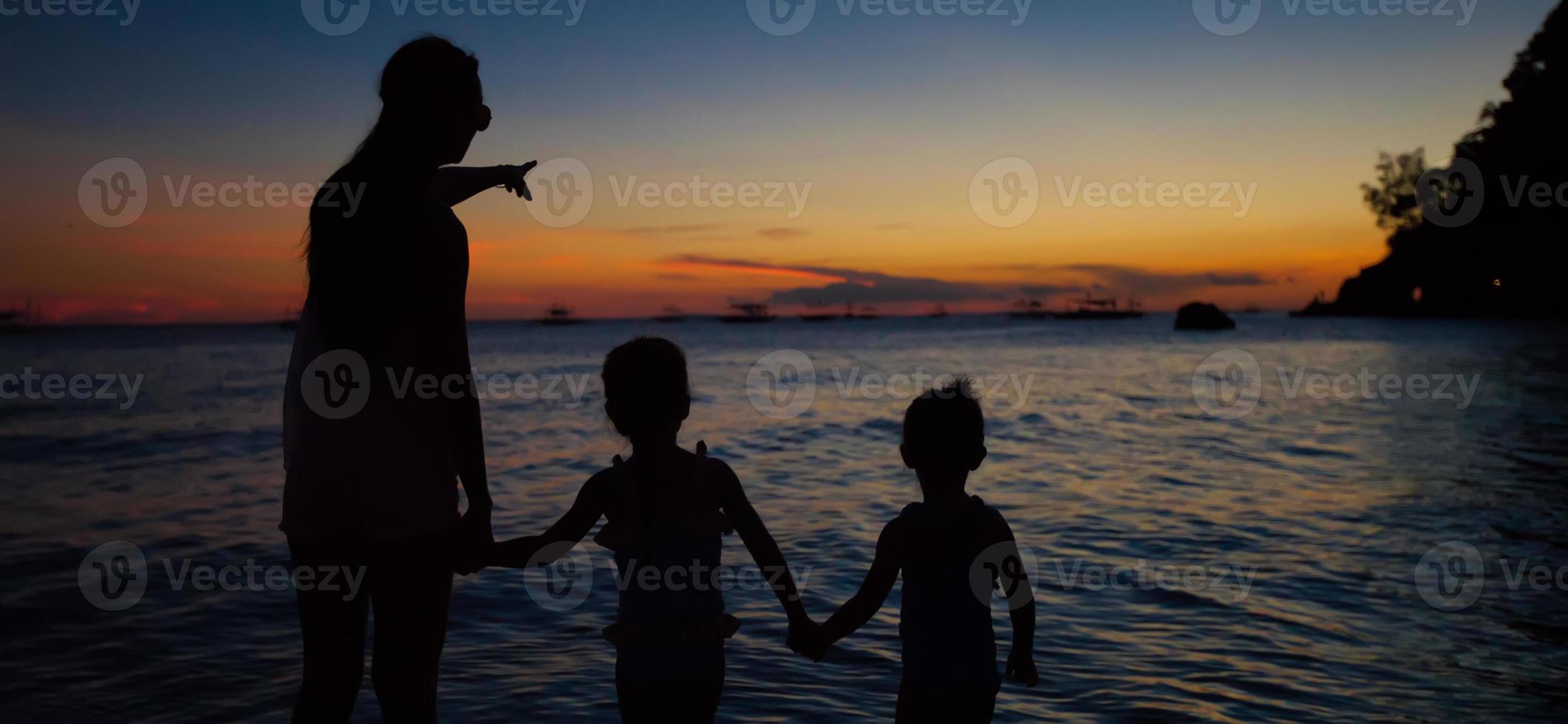 familia de tres siluetas al atardecer en la playa de boracay foto