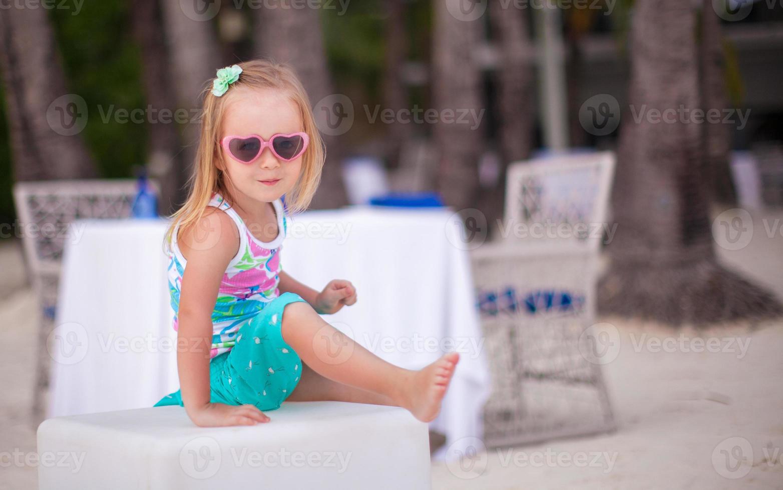 Portrait of little adorable girl on a tropical white beach photo