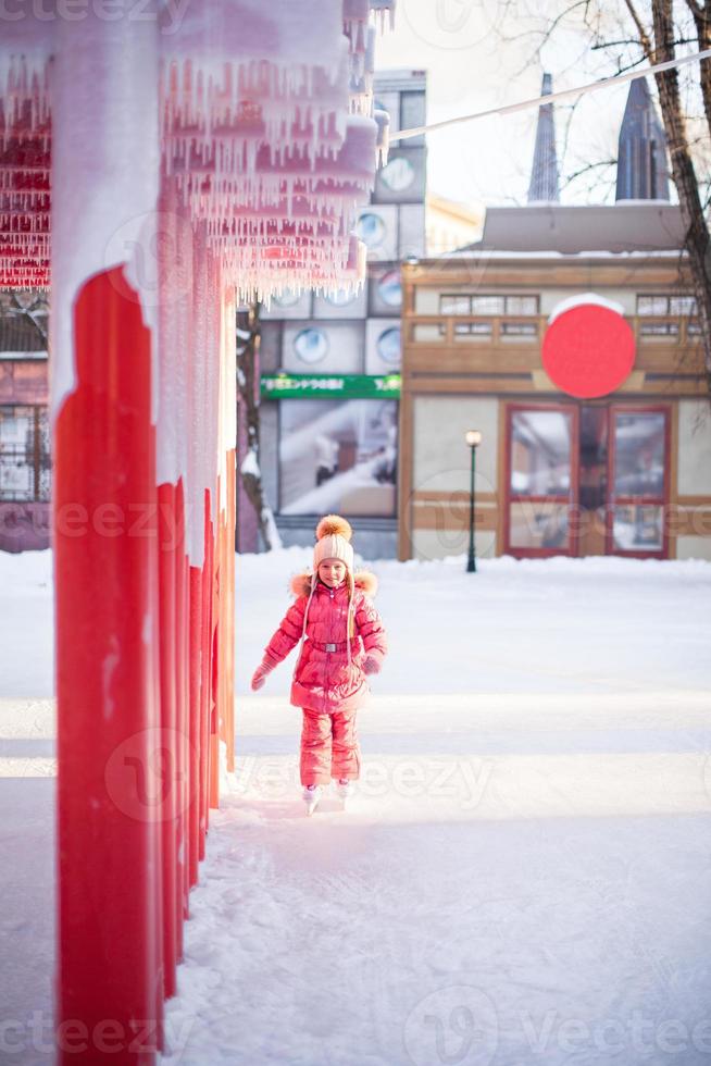Closeup icicles on a background of little girl to skate photo