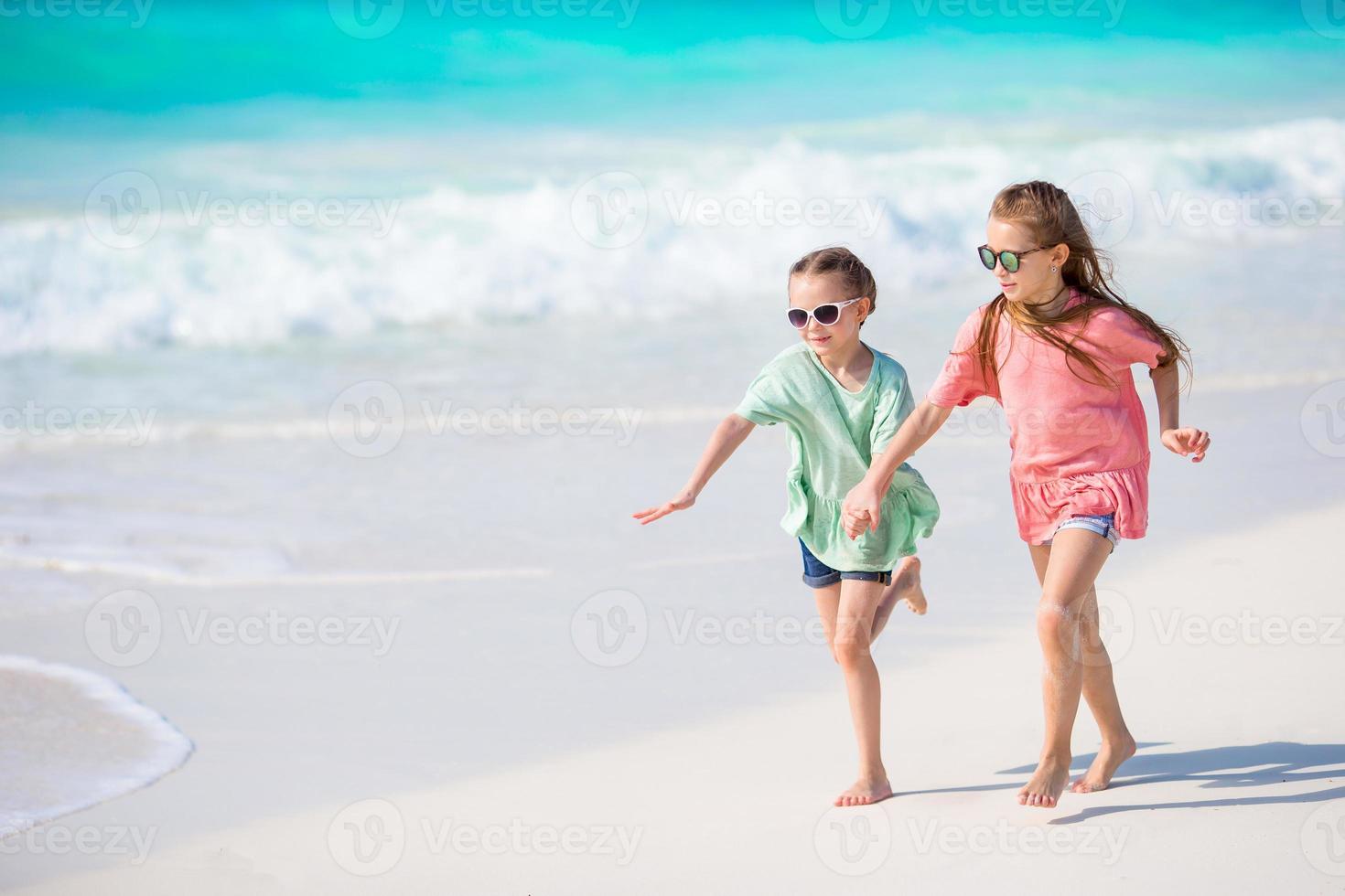 Adorable little kids play together on the beach photo