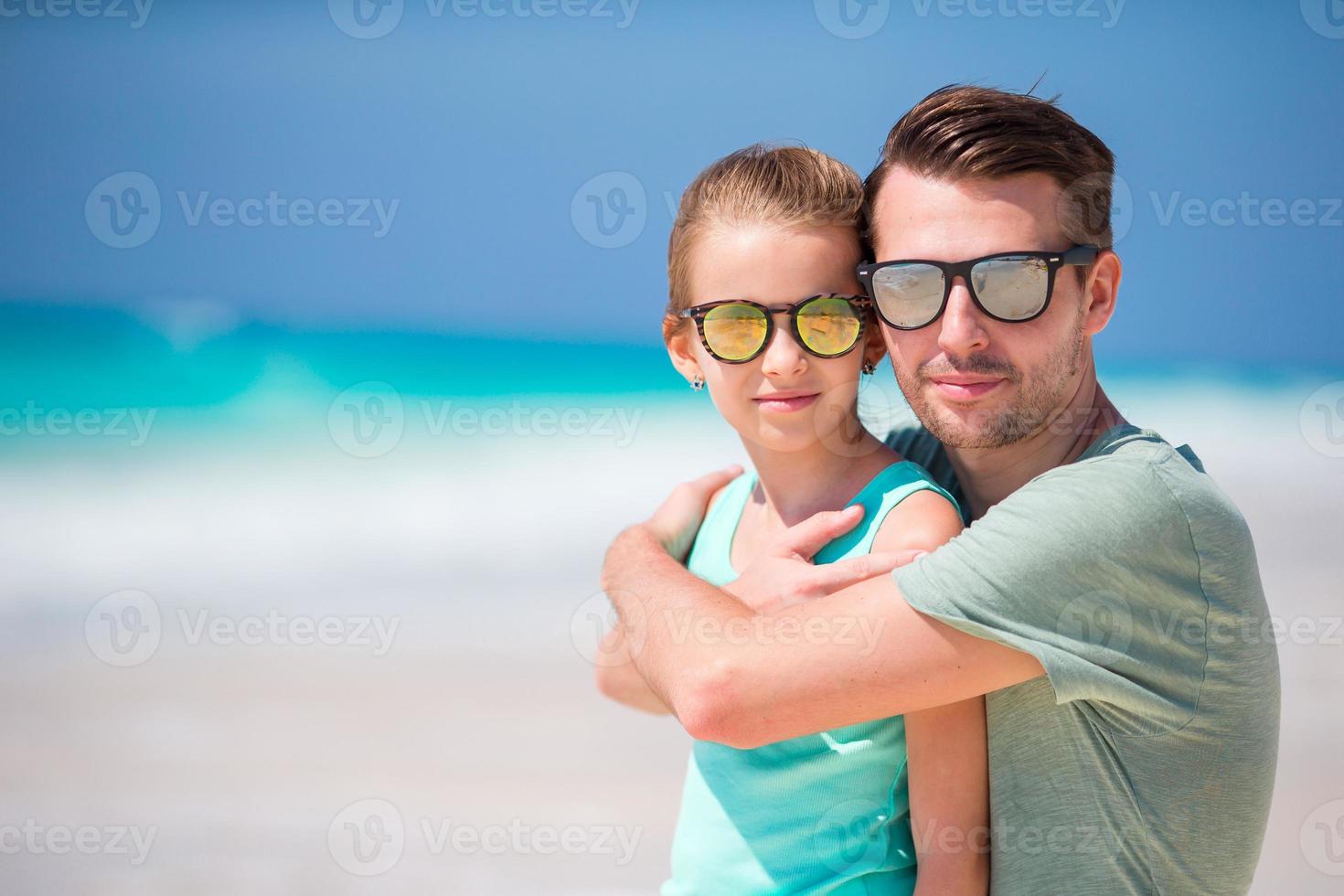 Portrait of dad and his adorable little daughter at white beach photo