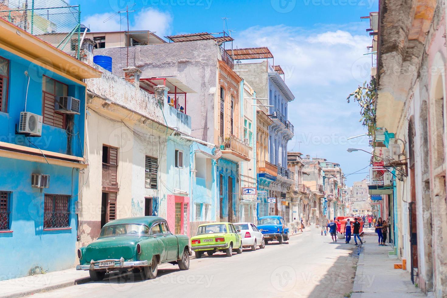 vista auténtica de una calle de la habana vieja con edificios y autos antiguos foto