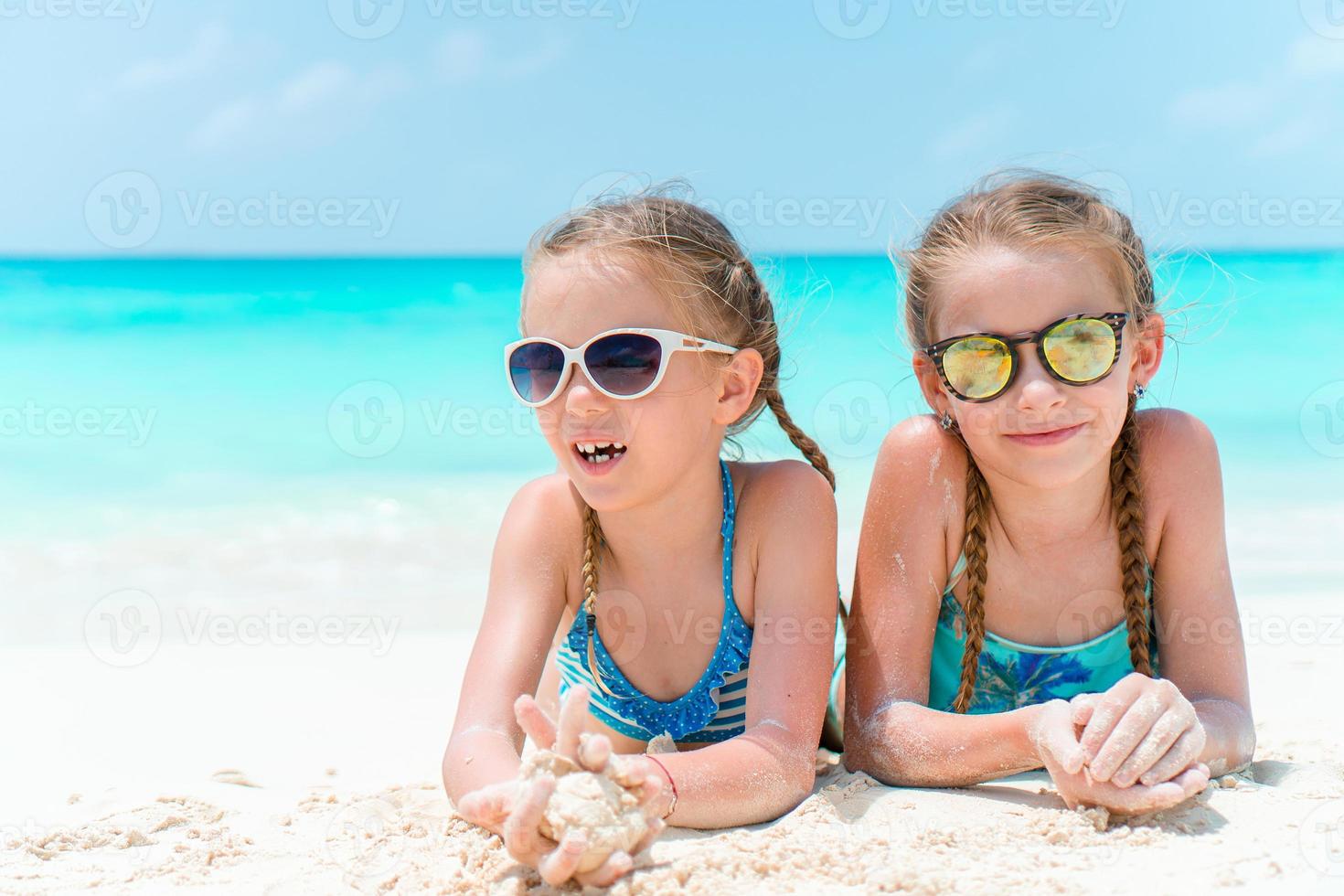 Portrait of two beautiful kids looking at camera background of beautiful nature of blue sky and turquoise sea photo