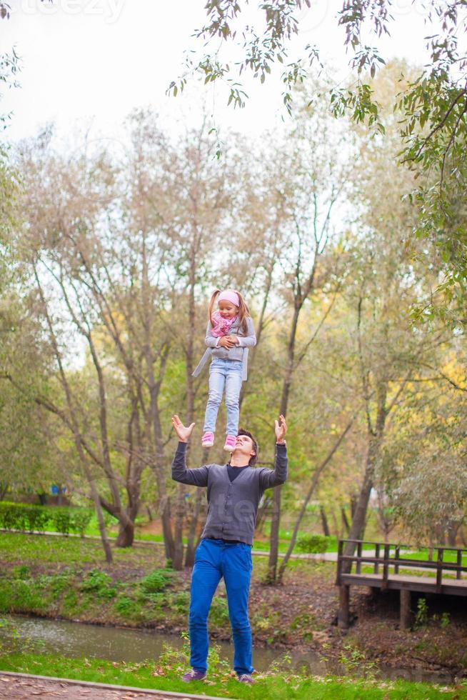 Young father with his cute little daughter have fun outdoor in the park photo