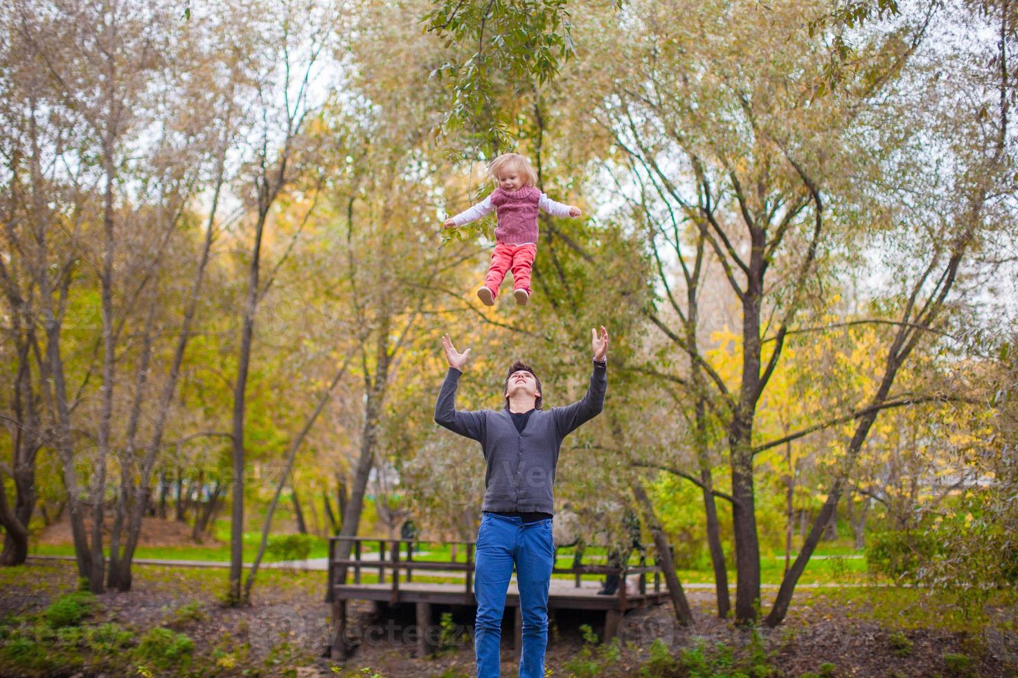 Young father with his cute little daughter have fun outdoor in the park photo