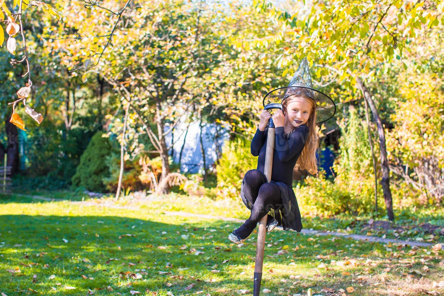 Adorable little girl in Halloween which costume having fun outdoors photo