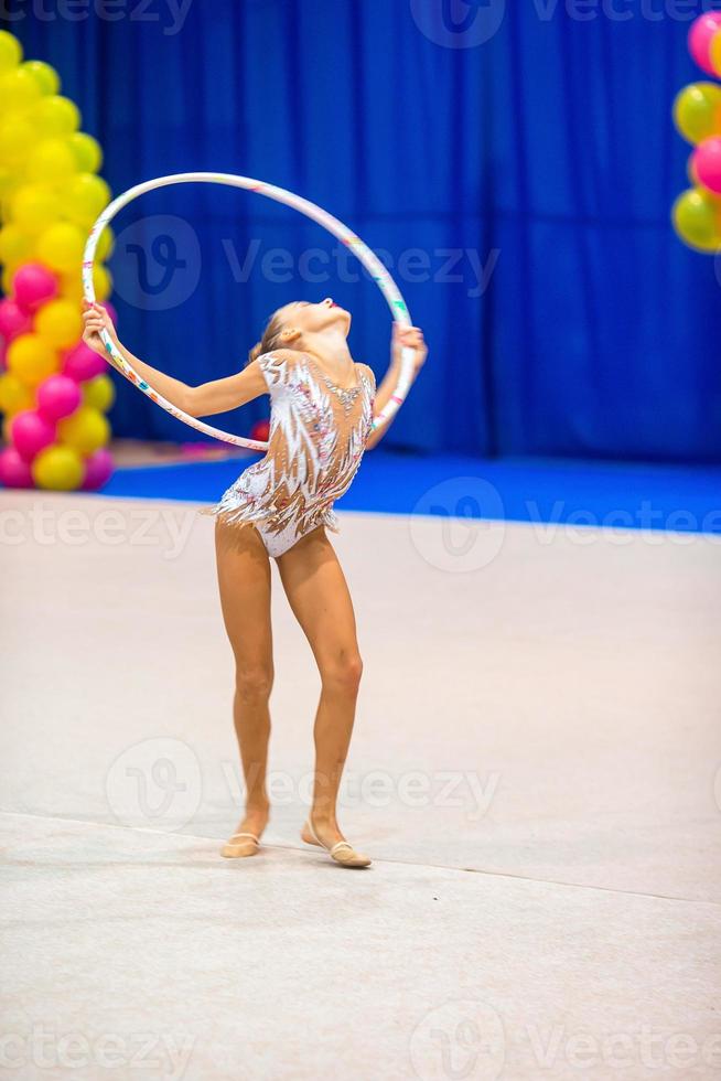 hermosa niña gimnasta en la alfombra de la competencia foto