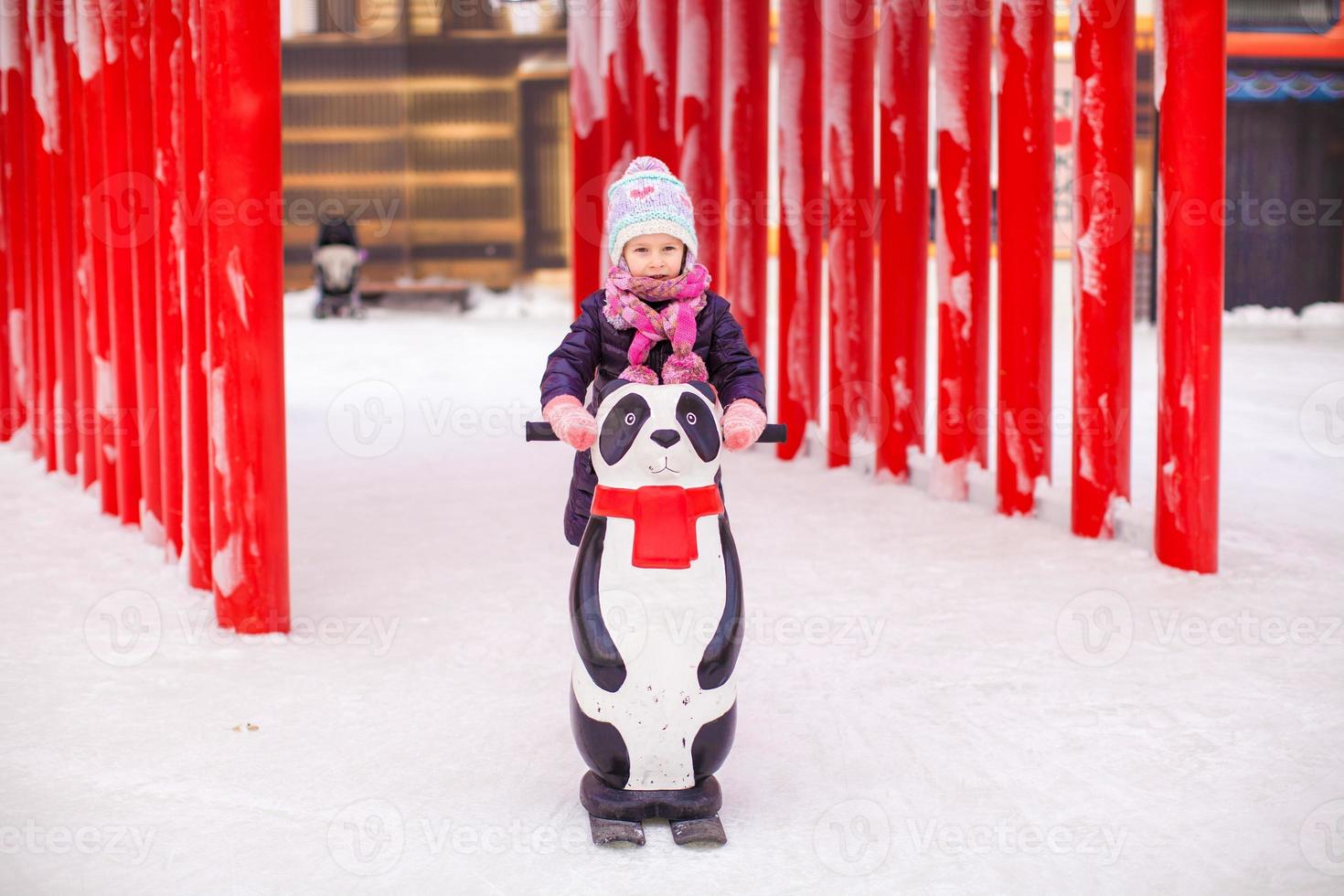 Little happy girl skating on the ice-rink photo