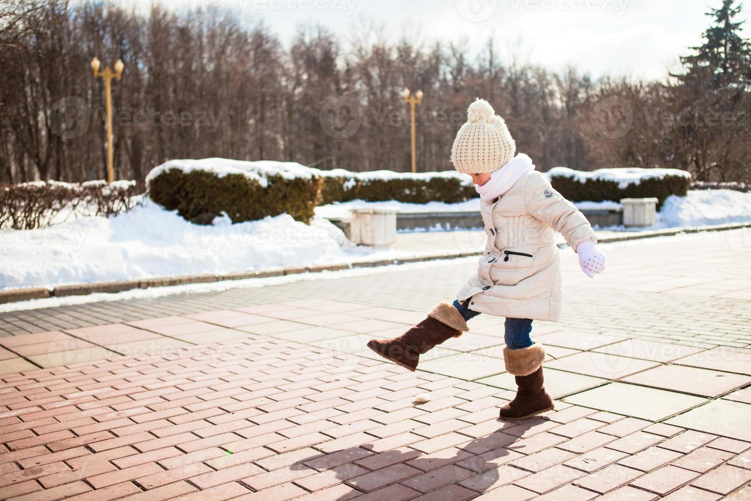 Little cute girl walks in the winter on a sunny day outdoors photo