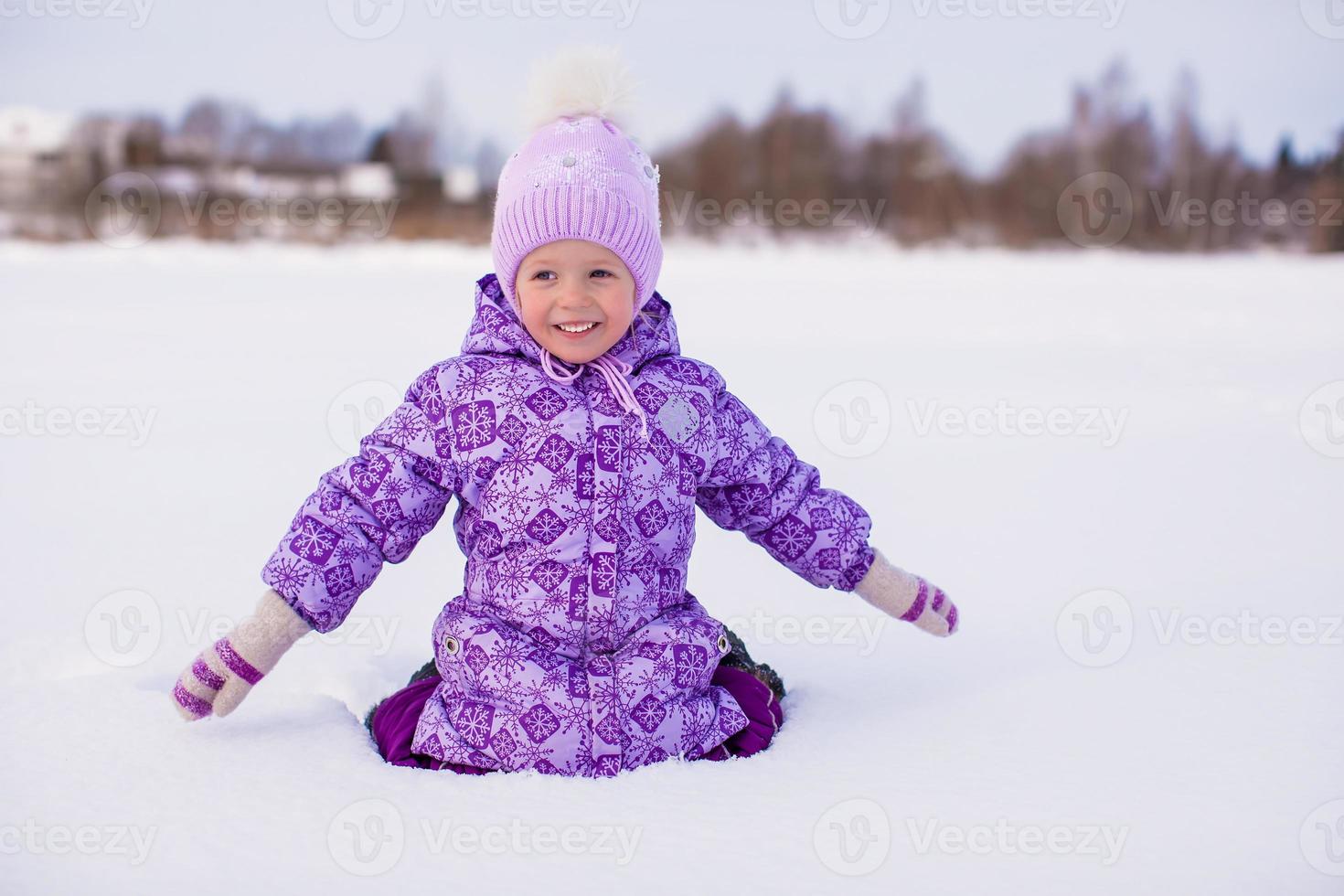 Little adorable girl enjoying snow winter sunny day photo