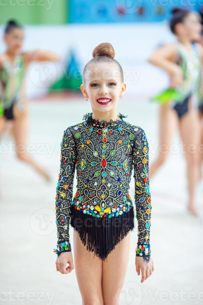 pequeña gimnasta entrenando en la alfombra y lista para las competencias foto