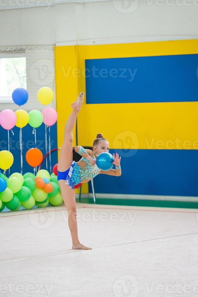 hermosa niña gimnasta activa con su actuación en la alfombra foto