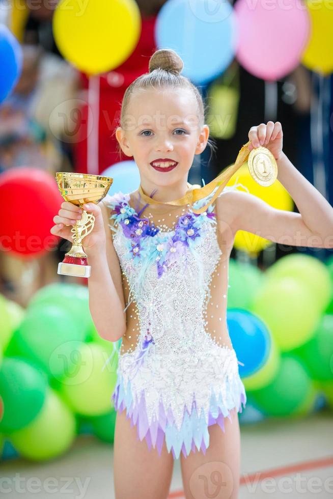 Beautiful little gymnast training on the carpet and ready for competitions photo